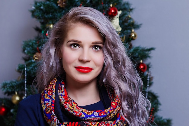 Retrato de uma linda mulher caucasiana posando contra o pano de fundo da árvore de Natal