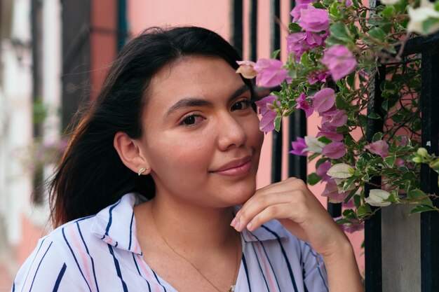 Retrato de uma linda mulher com cabelos castanhos compridos, numa rua da cidade.