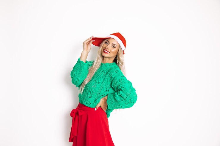 Foto retrato de uma linda mulher com chapéu de papai noel no natal, sorriso cheio de dentes, fundo branco com espaço de cópia, foto do estúdio, vestida na cor vermelha verde, segurando a mão