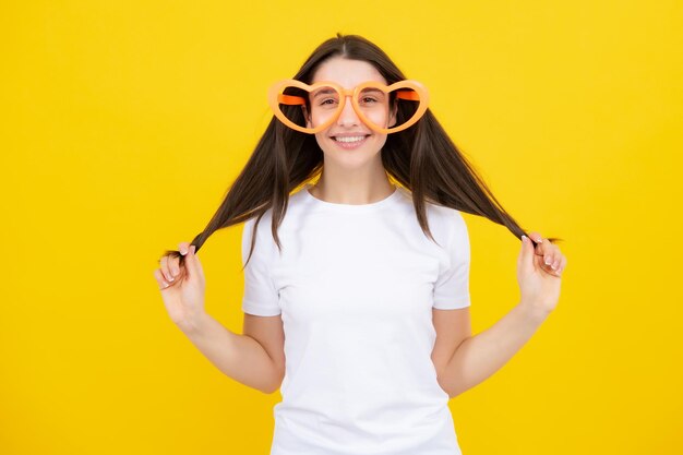 Retrato de uma linda mulher com óculos engraçados Celebração e festeira se divertindo retrato em fundo amarelo