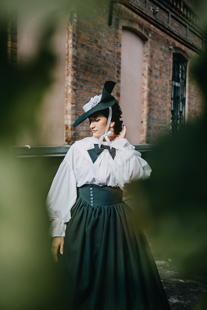 Retrato de uma linda mulher com roupas do início do chapéu verde vintage