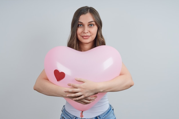 Retrato de uma linda mulher com um balão em forma de coração