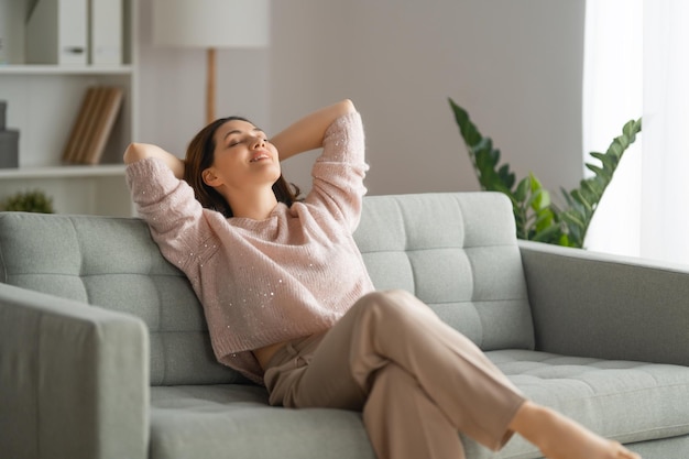 Retrato de uma linda mulher descansando em um sofá em casa