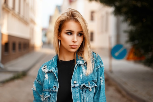 Retrato de uma linda mulher em jeans da moda na rua