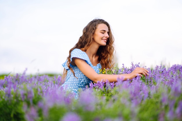 Retrato de uma linda mulher incrível em um campo florescente Férias na natureza relaxam e estilo de vida