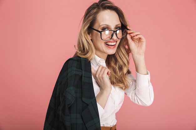 Foto retrato de uma linda mulher loira de 30 anos em uma roupa elegante, tocando óculos isolados no vermelho