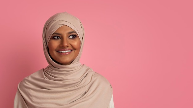 Retrato de uma linda mulher muçulmana em hijab, olhando de lado para o espaço da cópia