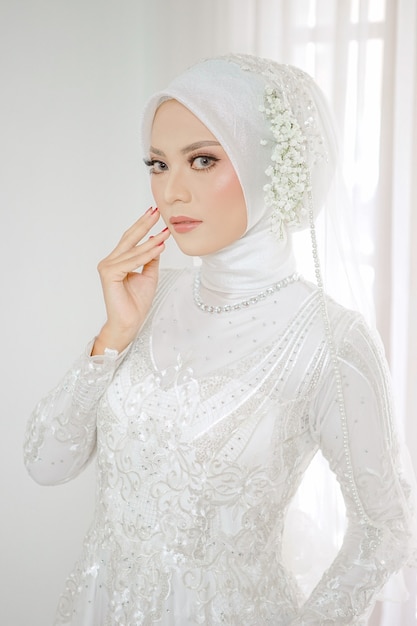 Retrato de uma linda mulher muçulmana usando um vestido de noiva branco