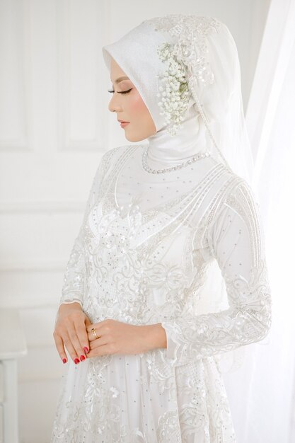 Retrato de uma linda mulher muçulmana usando um vestido de noiva branco