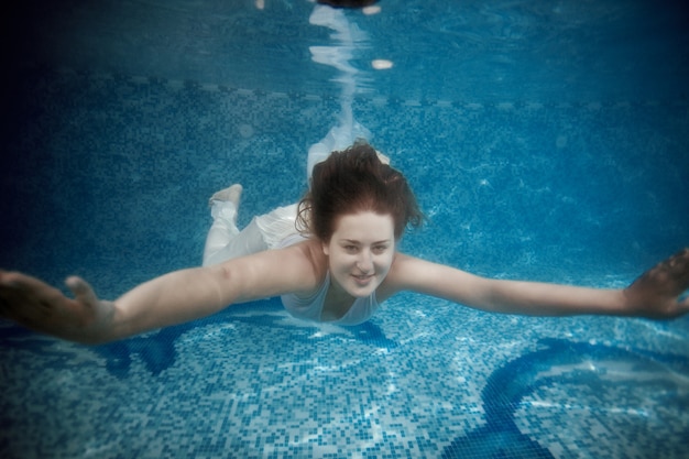 Retrato de uma linda mulher nadando debaixo d'água na piscina