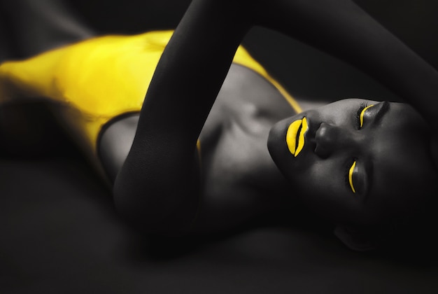 Retrato de uma linda mulher negra sensual no corpo amarelo