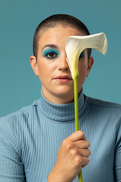 Foto retrato de uma linda mulher posando em uma gola alta com uma flor