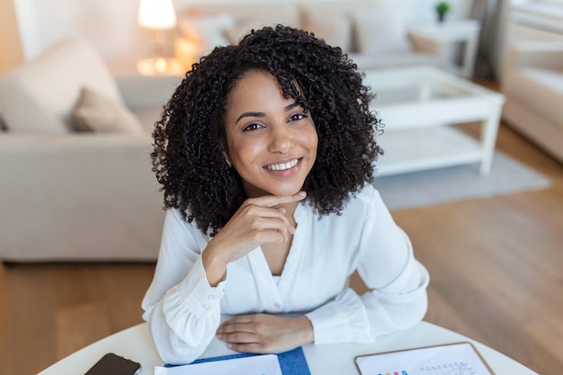 Retrato de uma linda mulher sorrindo em casa Mulher africana em casual olhando para a câmera com espaço de cópia Menina alegre de raça mista relaxando em casa com grande risada