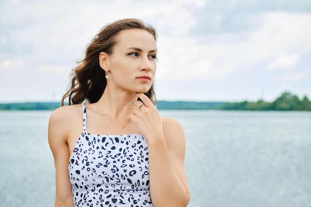 Retrato de uma linda mulher tocando seu queixo no lago