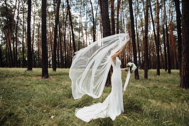 Retrato de uma linda noiva segurando um buquê de casamento na mão. doce noiva.