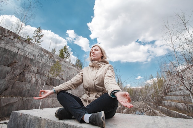 Retrato de uma loira meditando ao ar livre