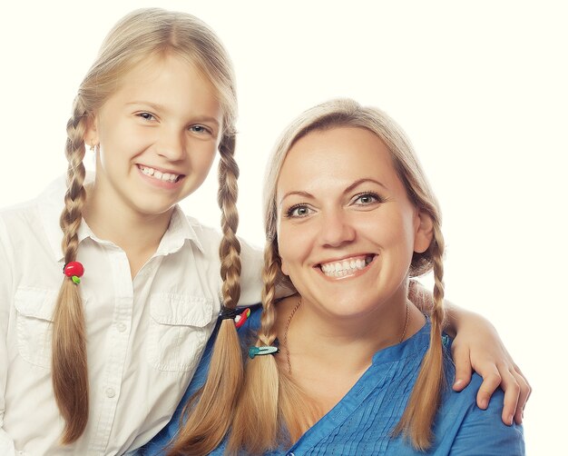 Retrato de uma mãe alegre e sua filha sorrindo na frente