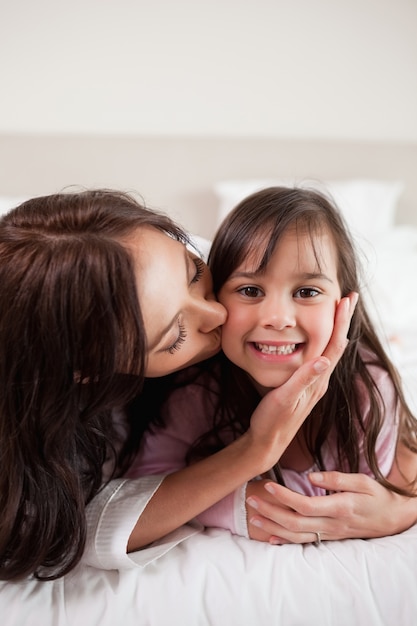 Retrato de uma mãe beijando sua filha