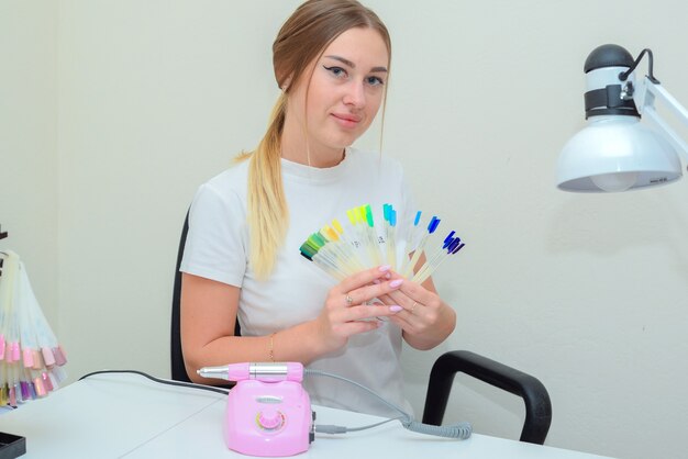 retrato de uma manicure mestre no salão no local de trabalho com ferramentas nas mãos