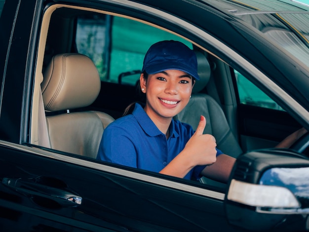 Foto retrato de uma mecânica gestando enquanto está sentada no carro