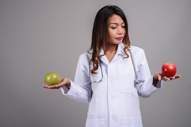 Retrato de uma médica asiática segurando duas maçãs