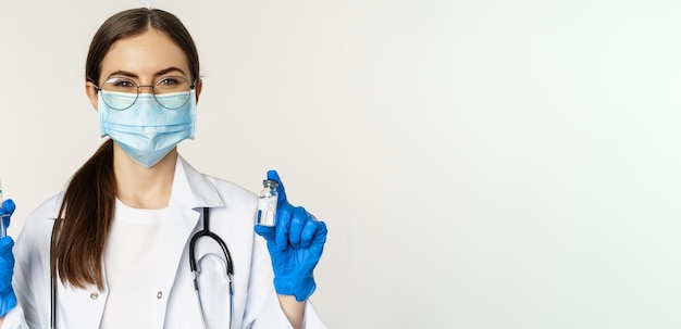 Foto retrato de uma médica segurando um estetoscópio contra um fundo branco