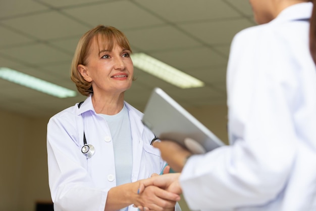 Retrato de uma médica sorridente examinando um paciente em um hospital