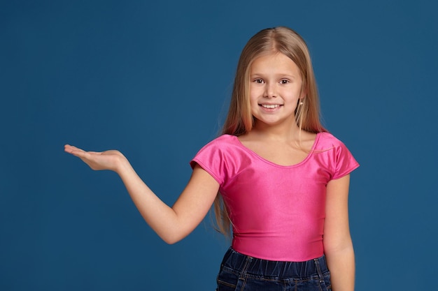 Foto retrato de uma menina adorável e emocional sobre fundo azul