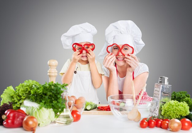 Retrato de uma menina adorável e sua mãe cozinhando juntas