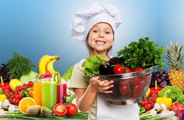 Retrato de uma menina adorável preparando comida saudável na cozinha