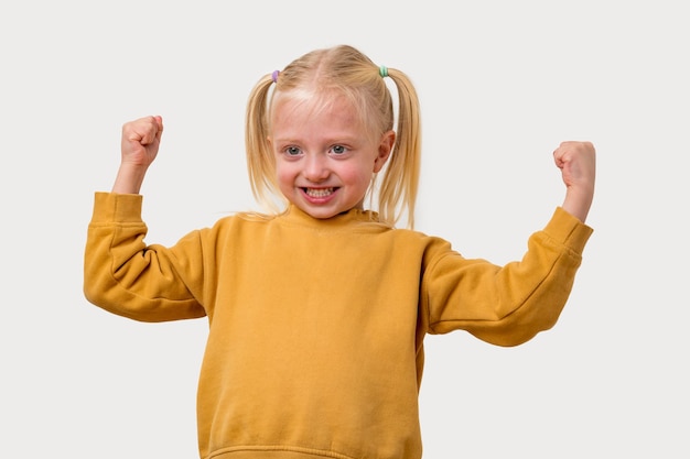 Foto retrato de uma menina alegre com uma camisola amarela