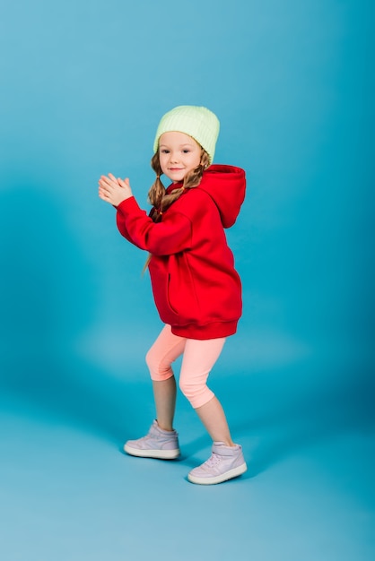 Retrato de uma menina alegre pulando e dançando contra um fundo de estúdio