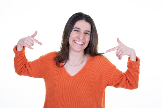 Foto retrato de uma menina animada e alegre apontando o dedo e orgulhosa dela