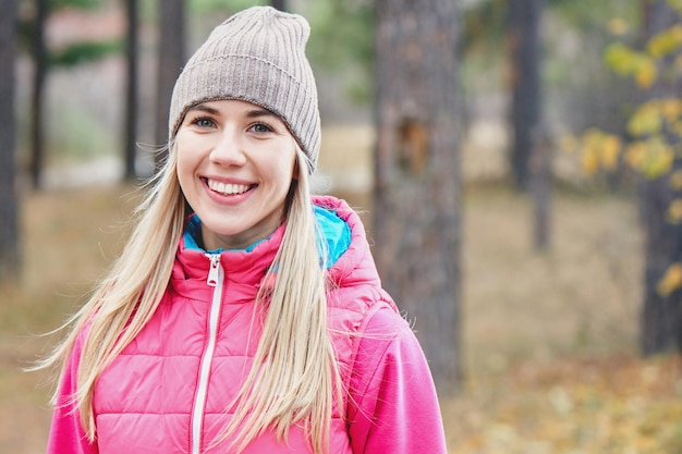 Retrato de uma menina atletas de jaqueta e boné na floresta. Um estilo de vida saudavel