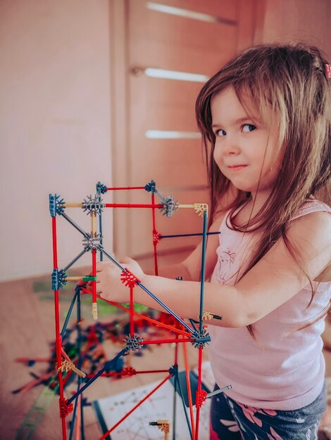 Retrato de uma menina bonita brincando com brinquedos em casa