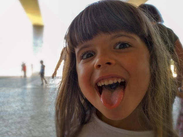 Foto retrato de uma menina bonita com a língua para fora