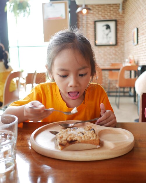 Foto retrato de uma menina bonita com comida num prato