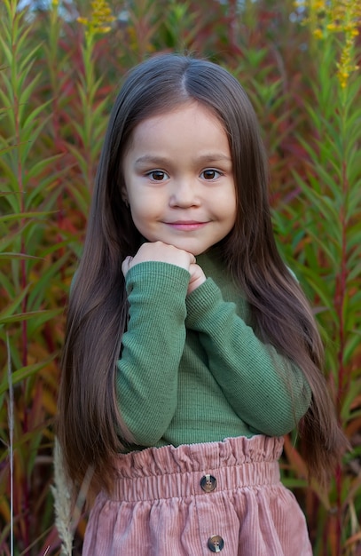 Retrato de uma menina bonita com longos cabelos escuros em um lugar natural