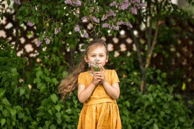 retrato de uma menina bonita com um buquê de miosótis