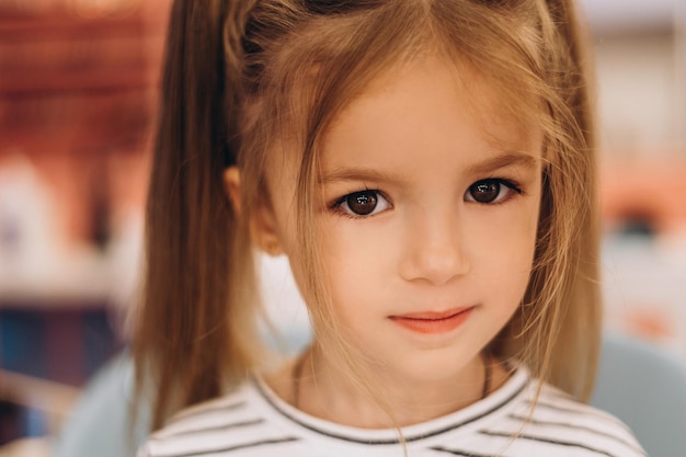 Retrato de uma menina bonita com um penteado elegante em um salão de beleza