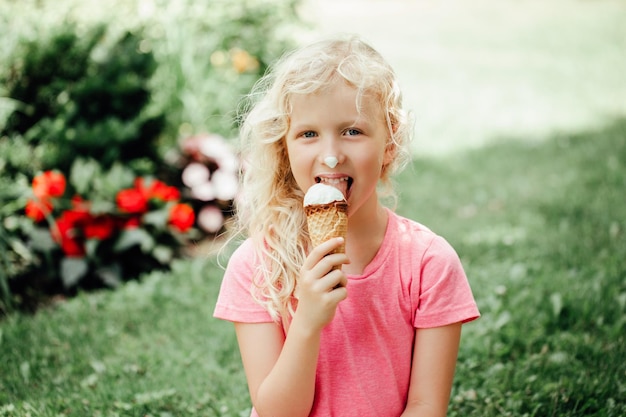 Retrato de uma menina bonita comendo sorvete ao ar livre