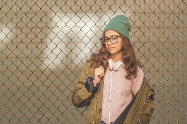 Retrato de uma menina bonita do adolescente com os vidros que levantam fora.