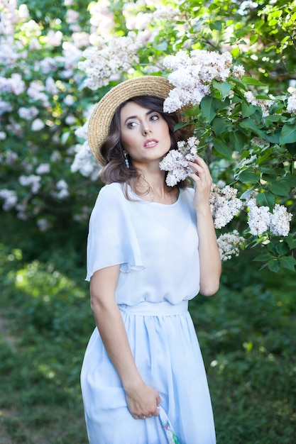 retrato de uma menina bonita em um jardim de verão lilás jovem caminha no parque