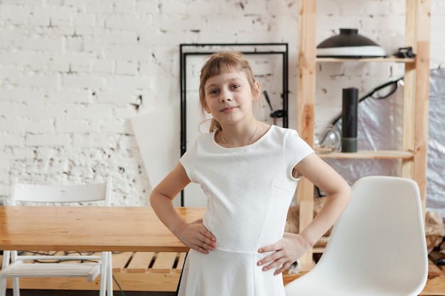 Retrato de uma menina bonita loira de 8 anos, no fundo da mesa