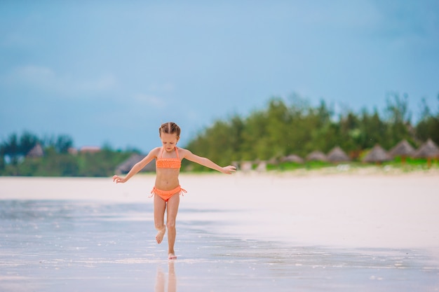 Retrato de uma menina bonita na praia dançando