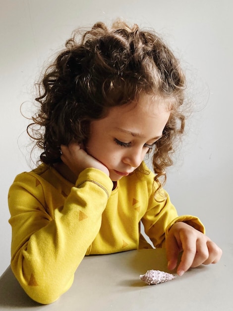 Foto retrato de uma menina bonita olhando para a mesa