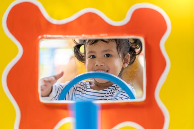 Foto retrato de uma menina bonita olhando pela janela de um carro de brinquedo