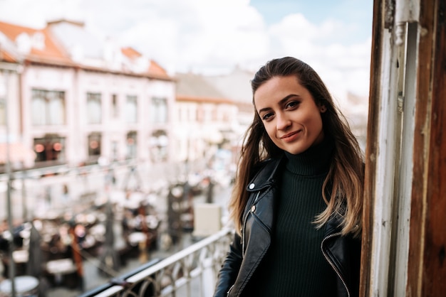 Retrato de uma menina bonita que está em um terraço na cidade.