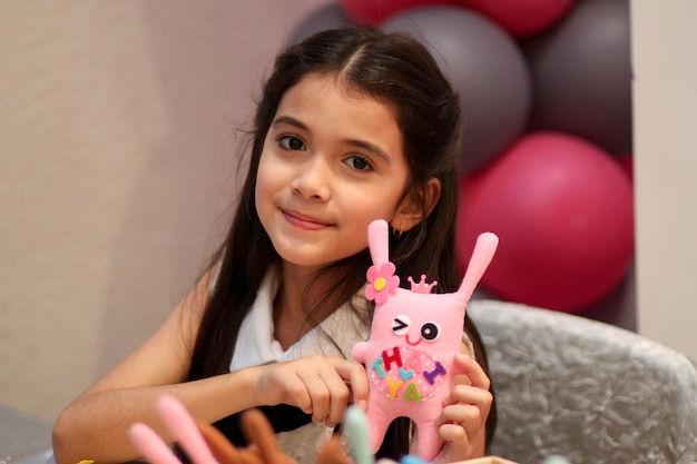 Foto retrato de uma menina bonita segurando um brinquedo em casa