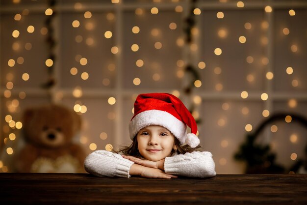 Foto retrato de uma menina bonita sentada na mesa